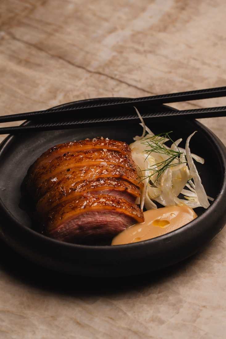 Sliced lacquered crispy pork belly with shaved fennel and dill