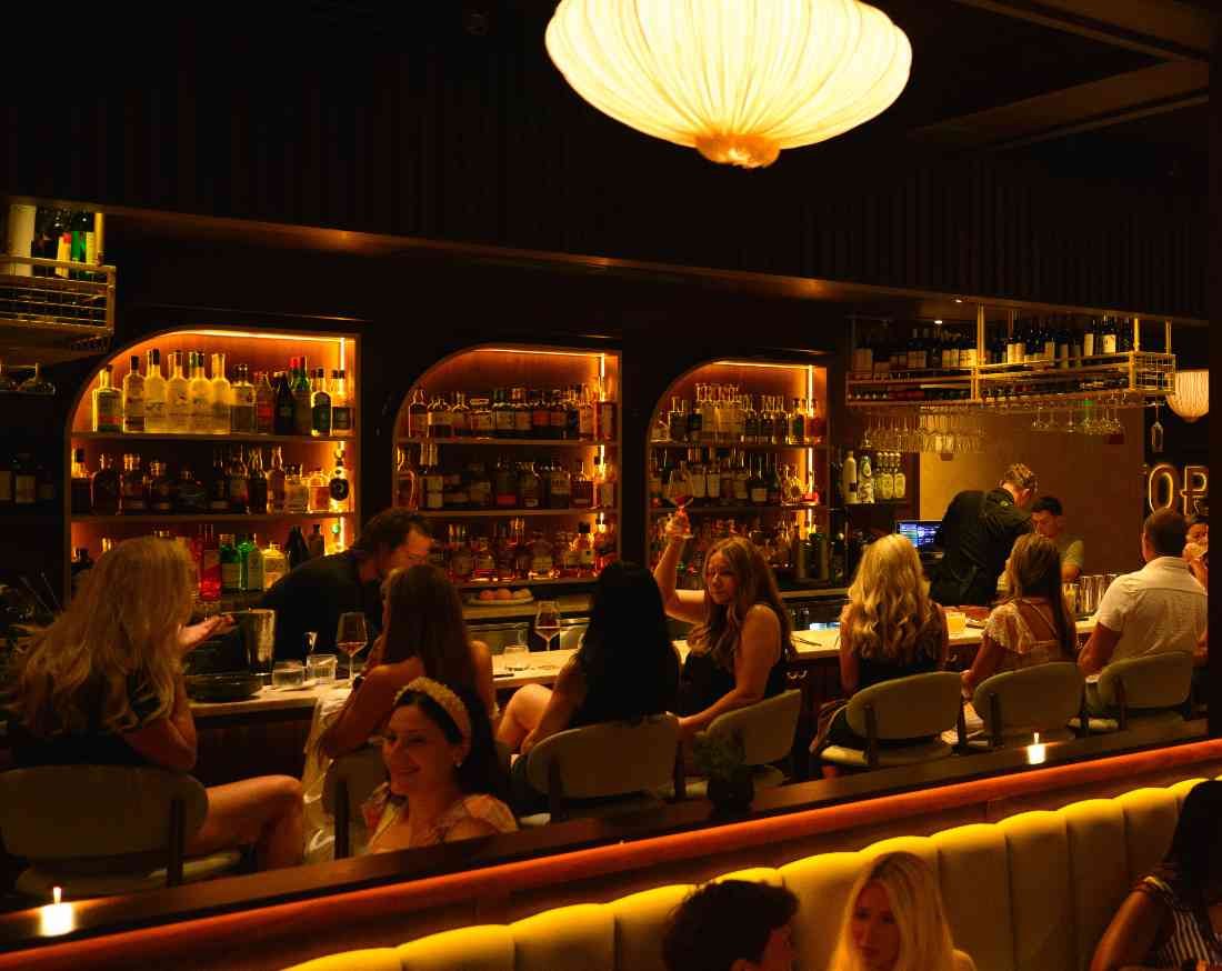 The Fortu bar, arched backlit liquor niches and hanging stemware