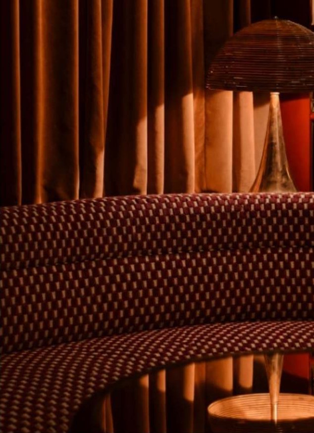 Curved banquette in patterned oxblood upholstery