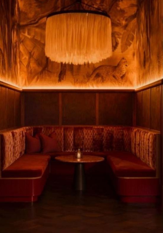 Corner booth beneath a pleated fringe pendant light