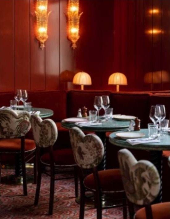 Dining room with brass sconces and set tables